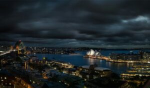 aerial shot of Sydney Harbour with the Sydney Opera House and Sydney Harbour Bridge lit up in the background